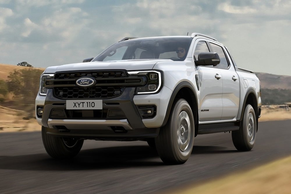 Een witte Ranger PHEV rijdt op een weg door de open natuur.