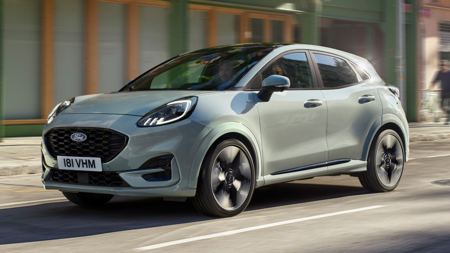 De grijze Ford Puma rijdt door de stad, zijaanzicht