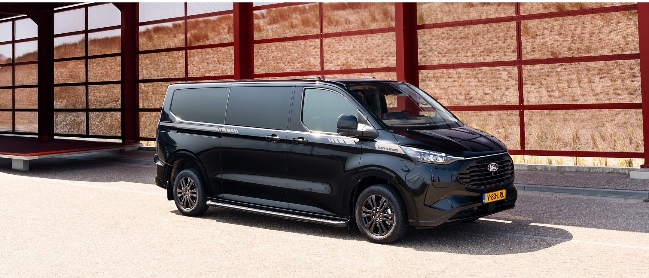 De zwarte Transit Custom Black Platinum staat geparkeerd, zijaanzicht