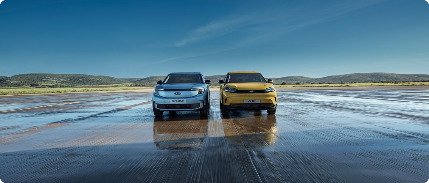 De voledig elektrische Ford Explorer(blauw) en Ford Capri(geel) rijdend op een open vlakte.