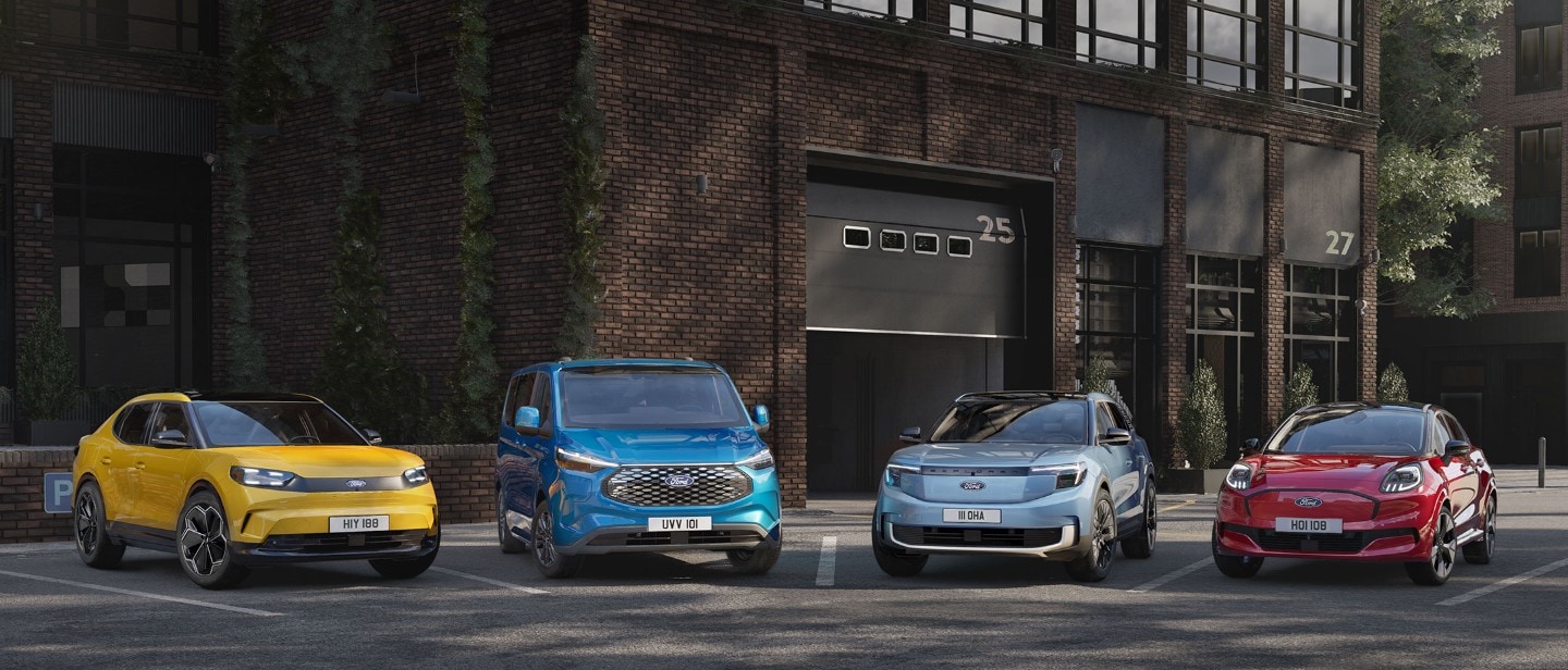 Vier Ford-voertuigen, een gele Capri, blauwe E-Transit Custom, zilveren Explorer en rode Puma Gen E, geparkeerd voor een gebouw.