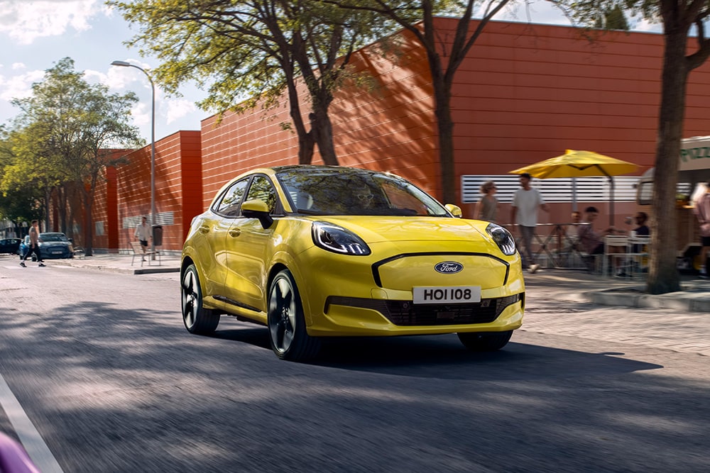 Gele Elektrische Ford Puma Gen-E rijd door de stad