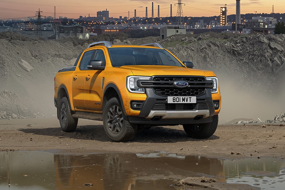 le Ford Ranger pick-up op een modderig bouwterrein bij zonsondergang.