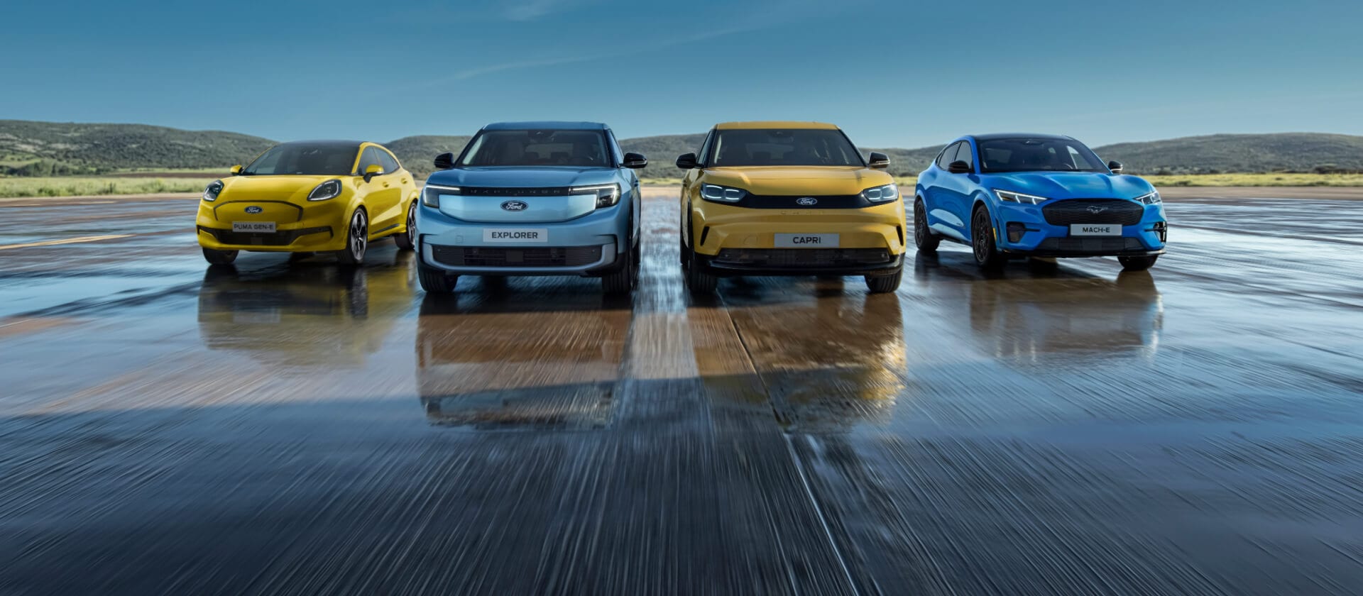 Een opstelling van het assortiment elektrische auto's van Ford, met de Ford Puma Gen-E, Ford Explorer, Ford Capri en Ford Mustang Mach-E.