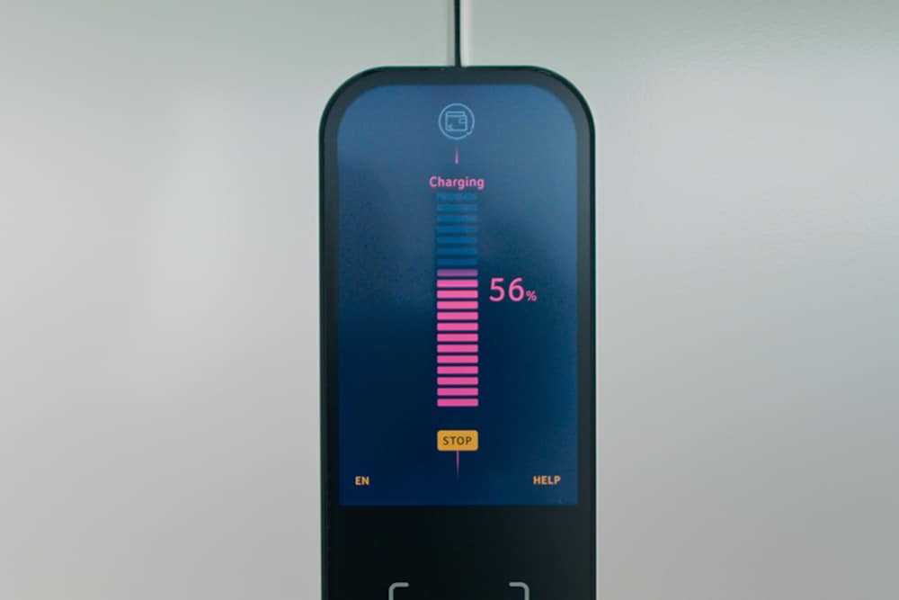 Close-up of a public EV charging station screen showing charging progress for a Ford electric car.
