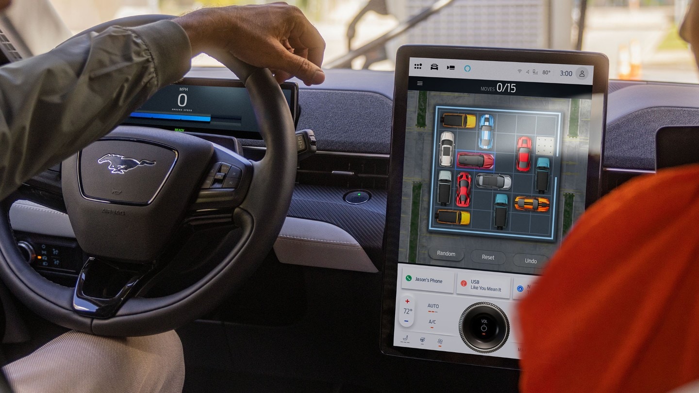 Het interieur van de Ford Mustang Mach-E met het stuur en het grote SYNC-touchscreen.