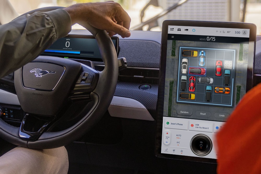 Het interieur van de Ford Mustang Mach-E met het stuur en het grote SYNC-touchscreen.