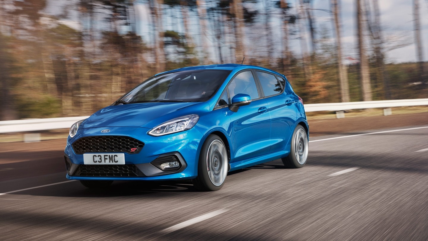 Blue Ford Fiesta ST driving on road bend