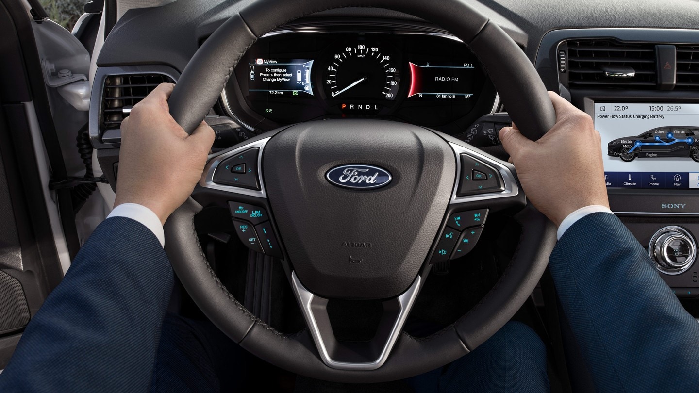 Detail of a man holding Ford Mondeo steering wheel while driving