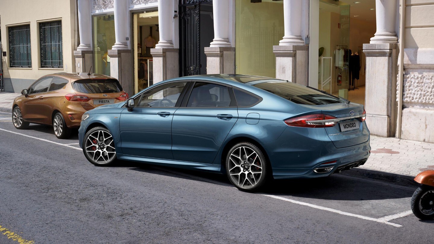 Blue Ford Mondeo driving out of parking bay
