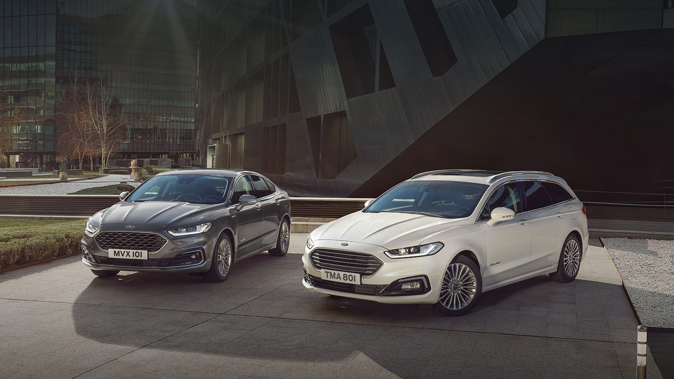 Dark and White Ford Mondeo parking in front of modern concrete building