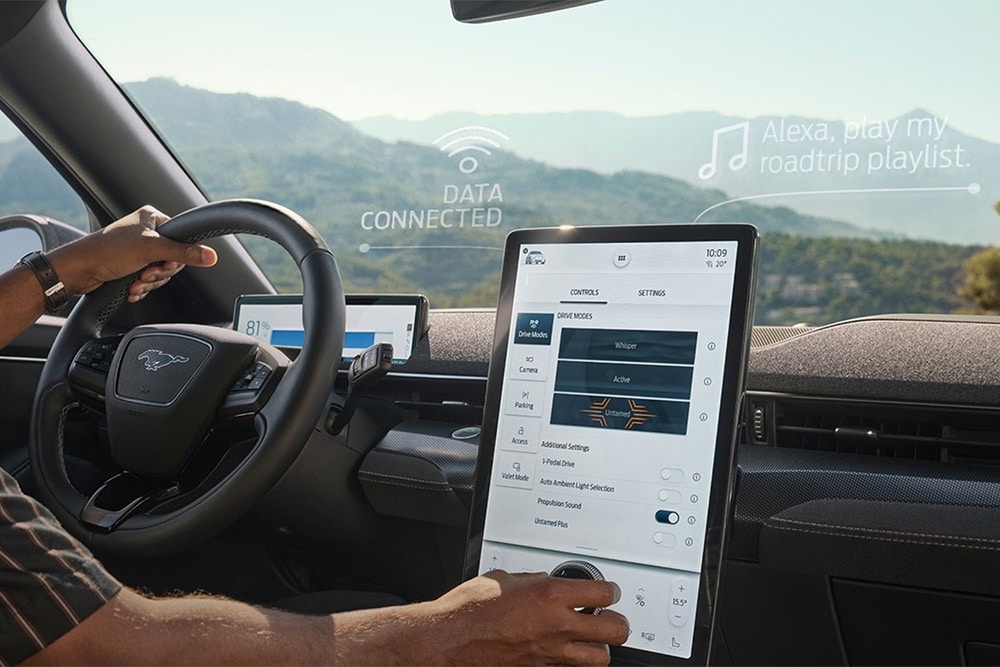 Een close-up van de bestuurder van een Ford Mustang Mach-E die interactie heeft met het grote 15,5" SYNC 4-touchscreen.