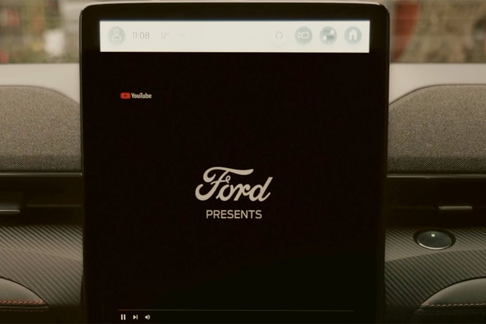 Close-up van het 15,5" SYNC 4-touchscreen met de tekst 'Ford presents' erop, om videostreaming in de auto te demonstreren.