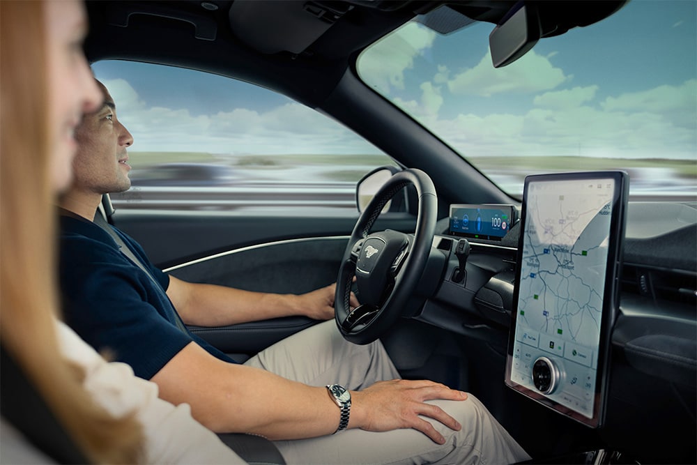 Close-up van een bestuurder en een passagier voor in een Mustang Mach-E.