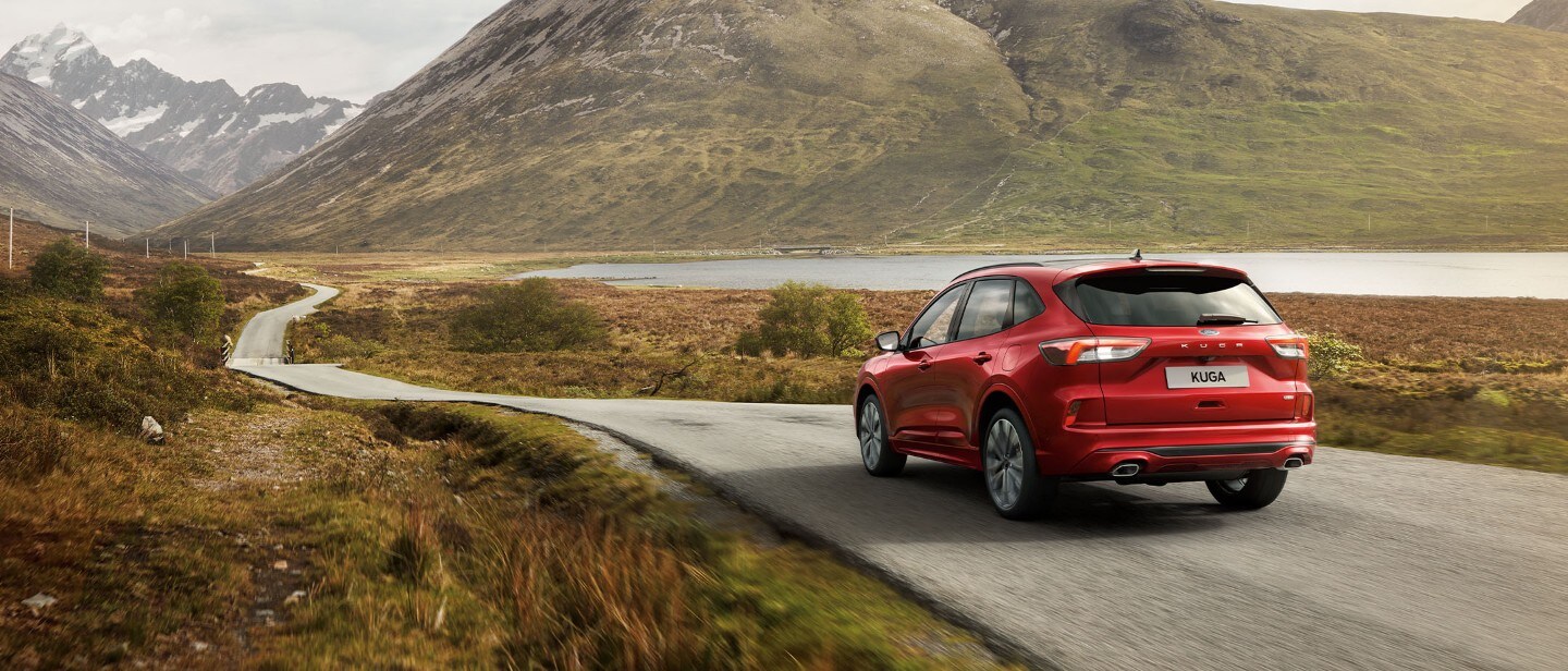 Ruby Red Ford Kuga driving a road in highlands
