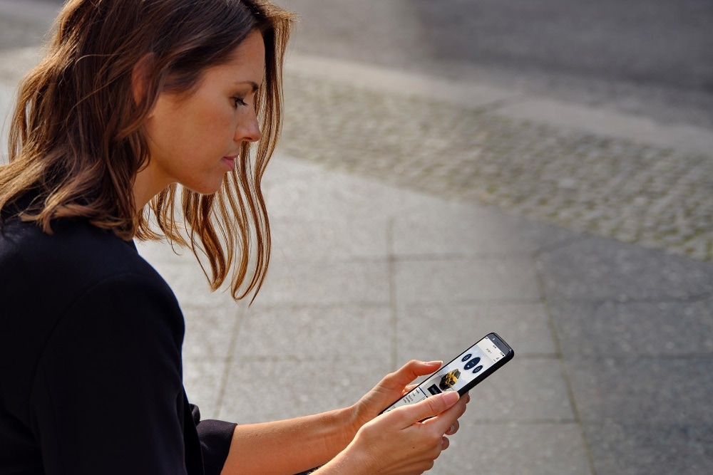Vrouw kijkt op FordPass via haar telefoon