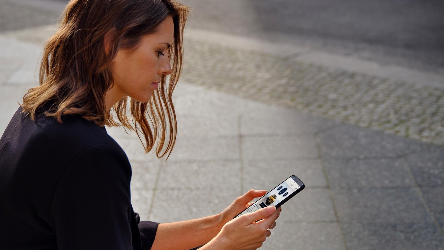 Vrouw kijkt op FordPass via haar telefoon