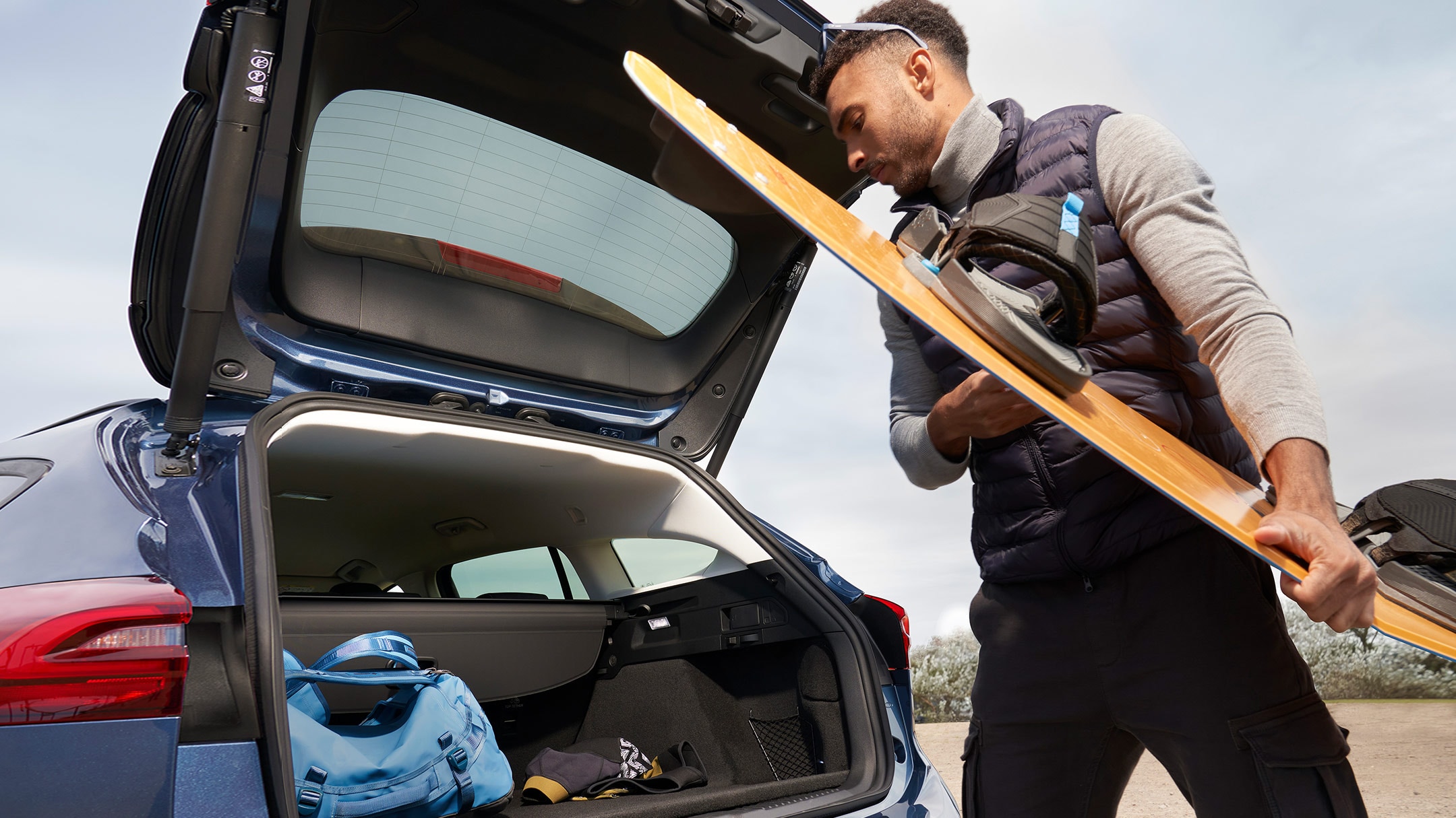 Man loading sports equipment into Focus load compartment