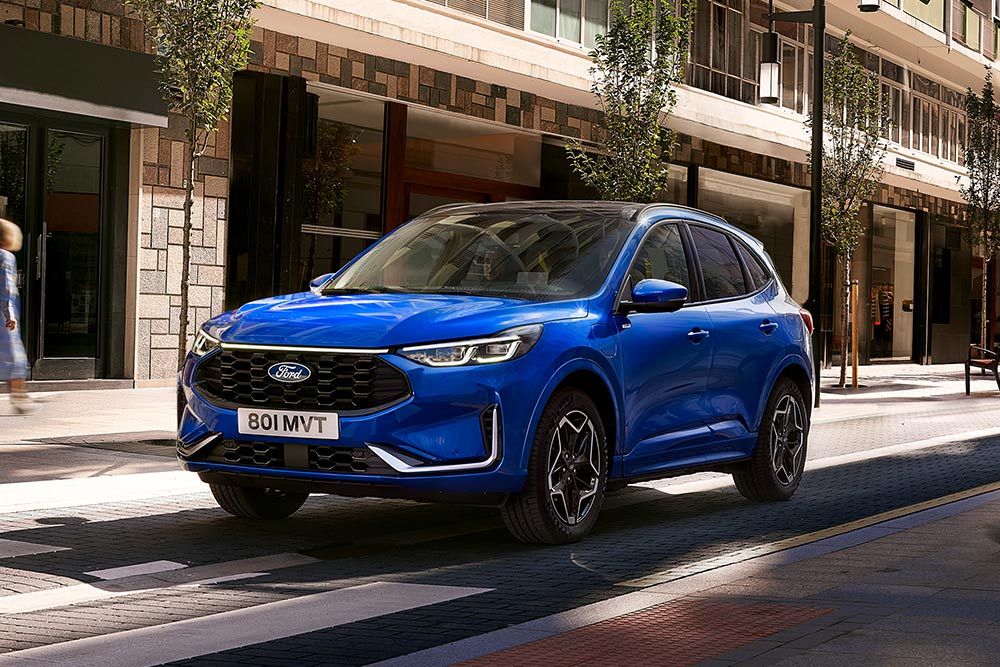 Een Ford Kuga ST Line in de kleur Desert Island Blue geparkeerd in een woonwijk. 