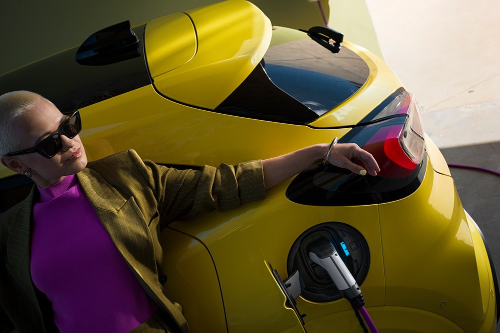 Een close-up van de achterkant van een elektrische Ford Puma Gen-E®, die thuis wordt opgeladen met een Wallbox.