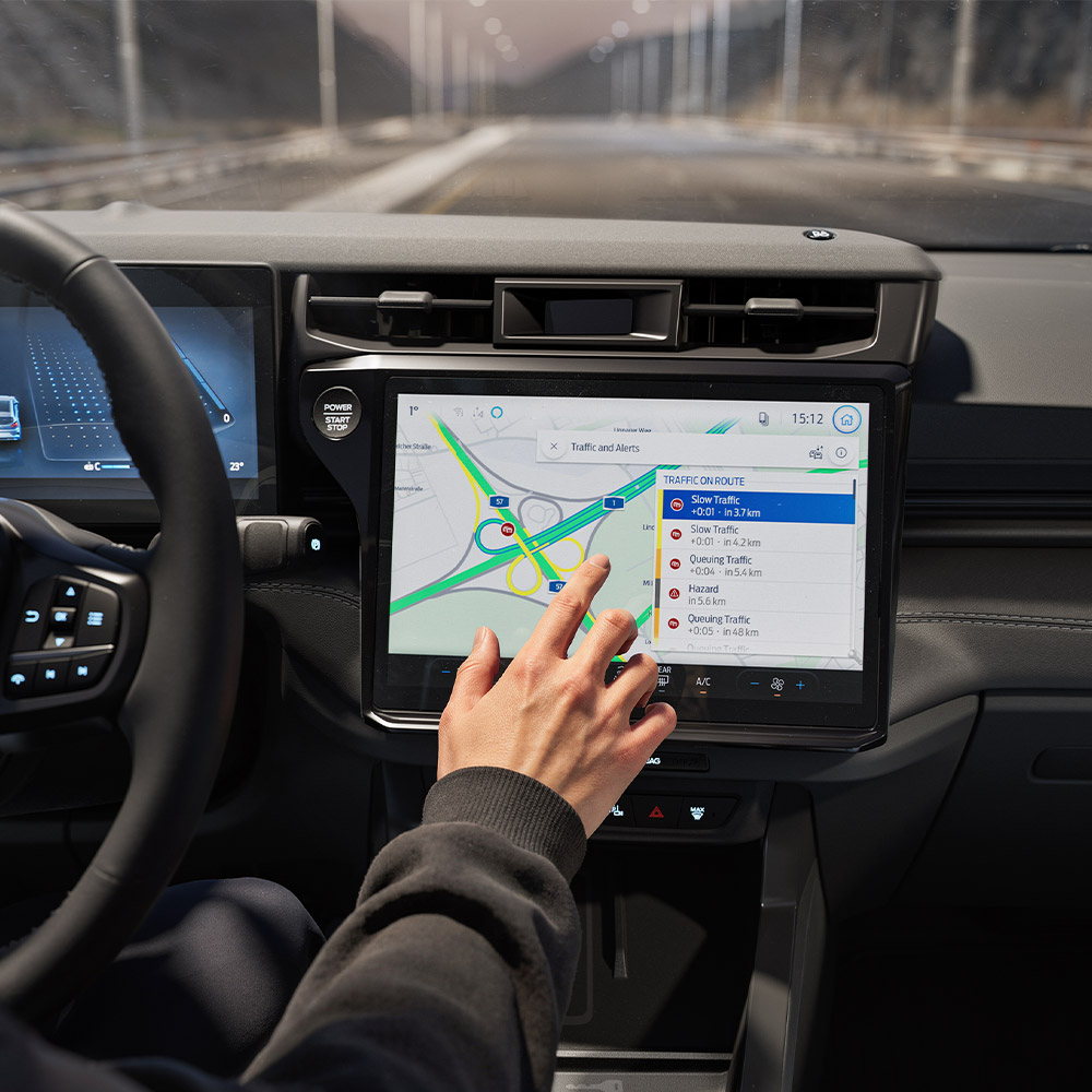 Een bestuurder gebruikt de Verbonden navigatie-functie op het digitale scherm van een Ford Puma Gen-E BlueCruise Edition.