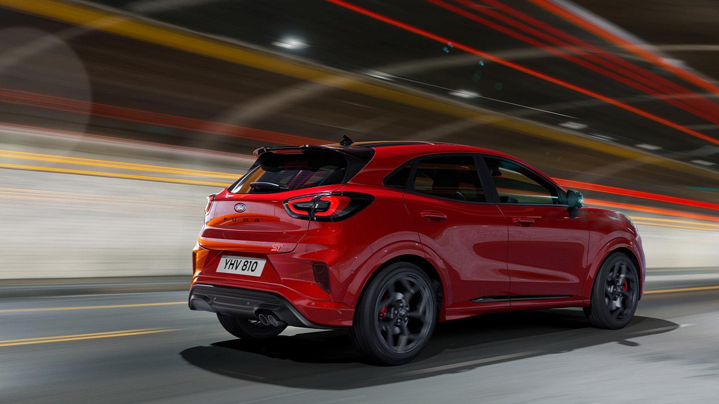 Red new Ford Puma ST driving rear view