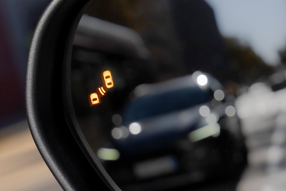 Een close-up van de Blindspot Information System-waarschuwing in de zijspiegel van de Ford Puma Gen-E®.