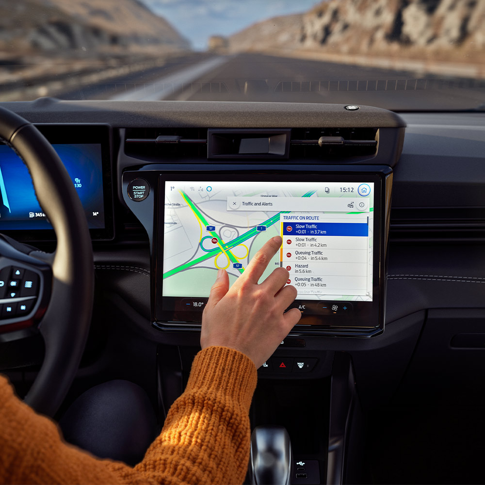 Een bestuurder gebruikt de Verbonden navigatie-functie op het digitale scherm van een Ford Puma BlueCruise Edition.