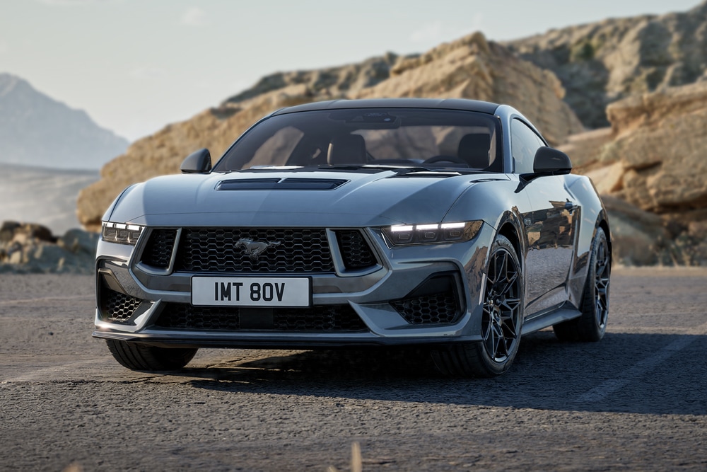 Grijze Ford Mustang Nite Pony die over een weg rijdt