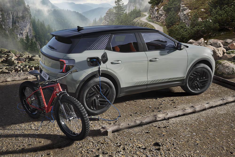 Een Ford Explorer® laadt een elektrische fiets op, geparkeerd in een bergachtige omgeving.