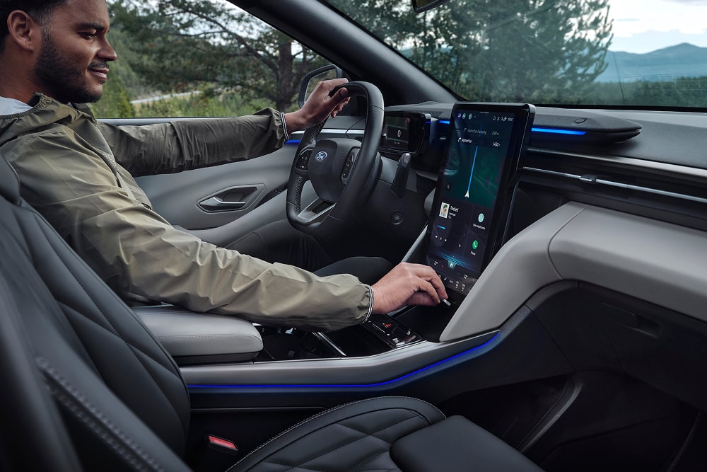 Een bestuurder gebruikt het touchscreen-infotainmentsysteem in de Ford Explorer gezins-SUV.