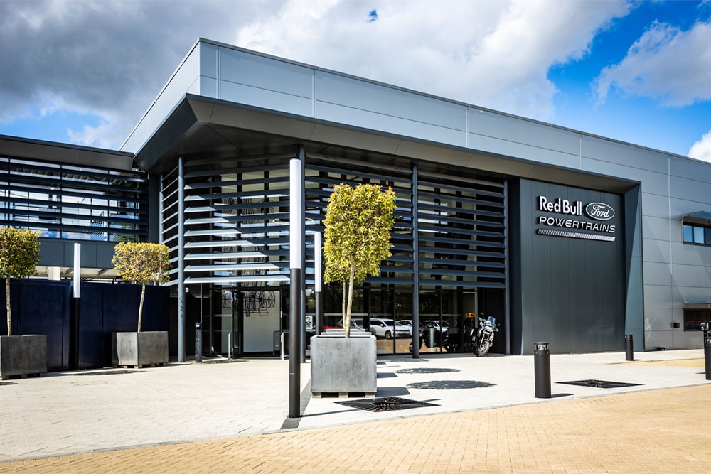 Het hoofdkantoor van Red Bull Ford Powertrains: een modern gebouw met het bedrijfslogo aan de buitenkant.