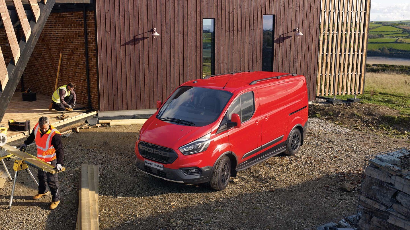 Rode Ford Transit Custom Trail geparkeerd op de klus