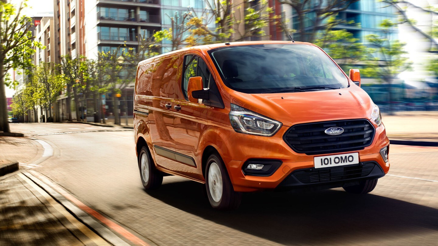 Orange Ford Transit Custom rijdend door de stad