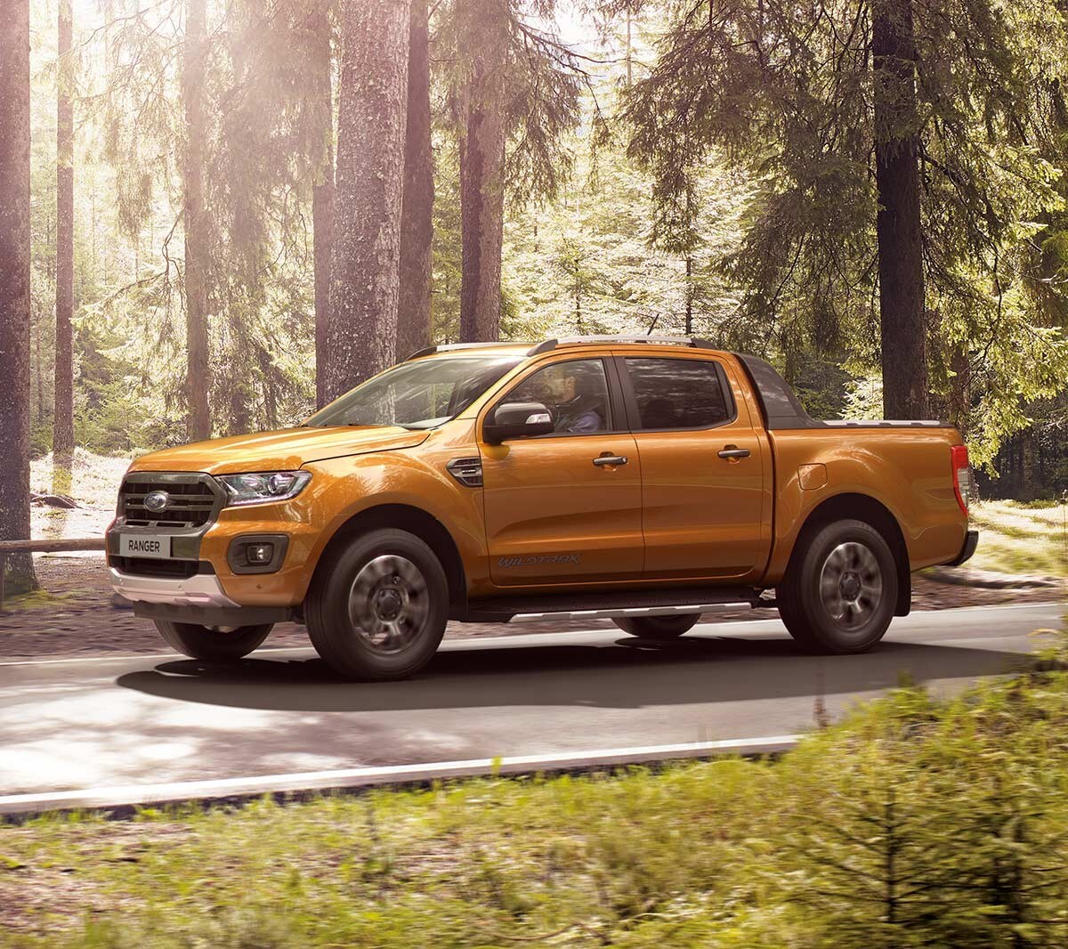 Oranje Ford Ranger zijaanzicht in het bos