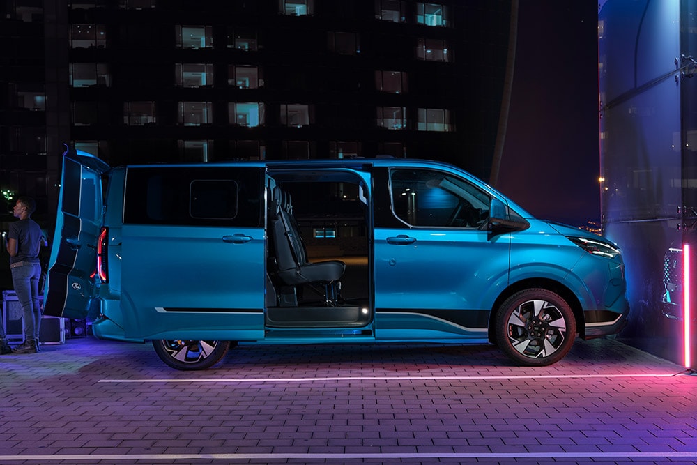 Blauwe Ford E-Transit Custom elektrische bestelbus met dubbele cabine en geopende deuren.