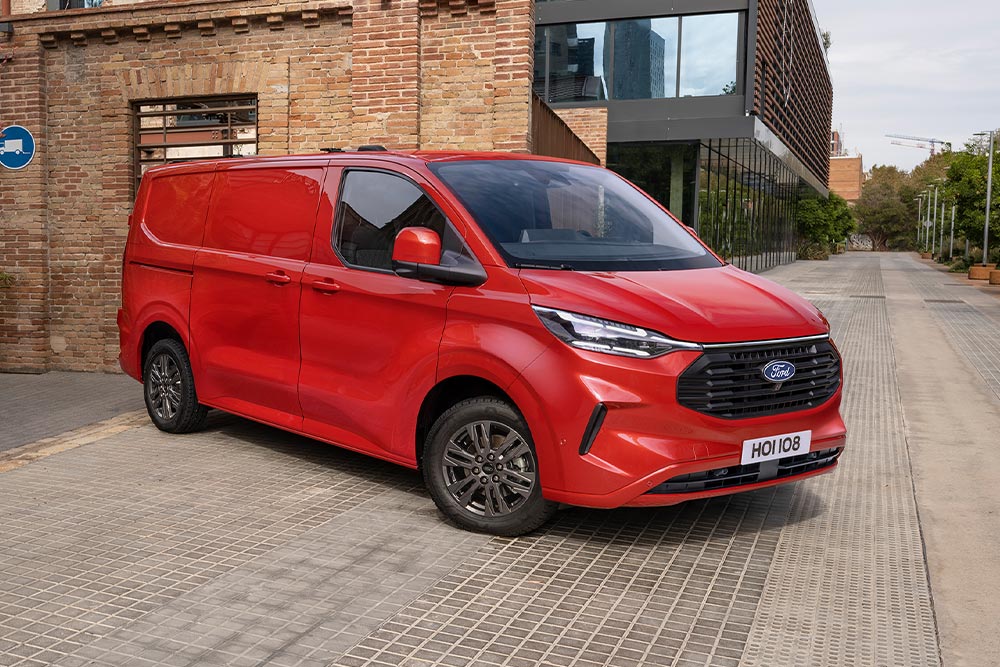 Rode Ford Transit Custom-bestelwagen geparkeerd op straat.