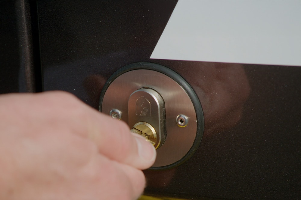 Een hand vergrendelt de deur van een bestelwagen met een sleutel.