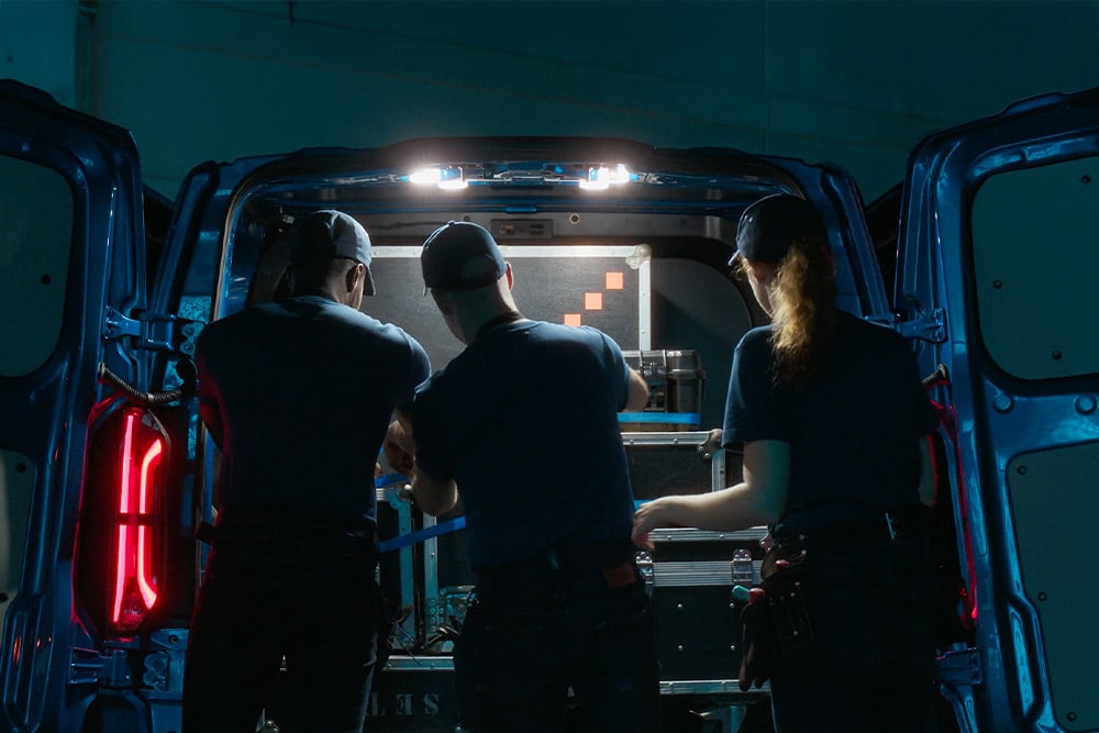 Drie mensen aan het werk achterin een Ford E-Transit Custom elektrische bestelbus.