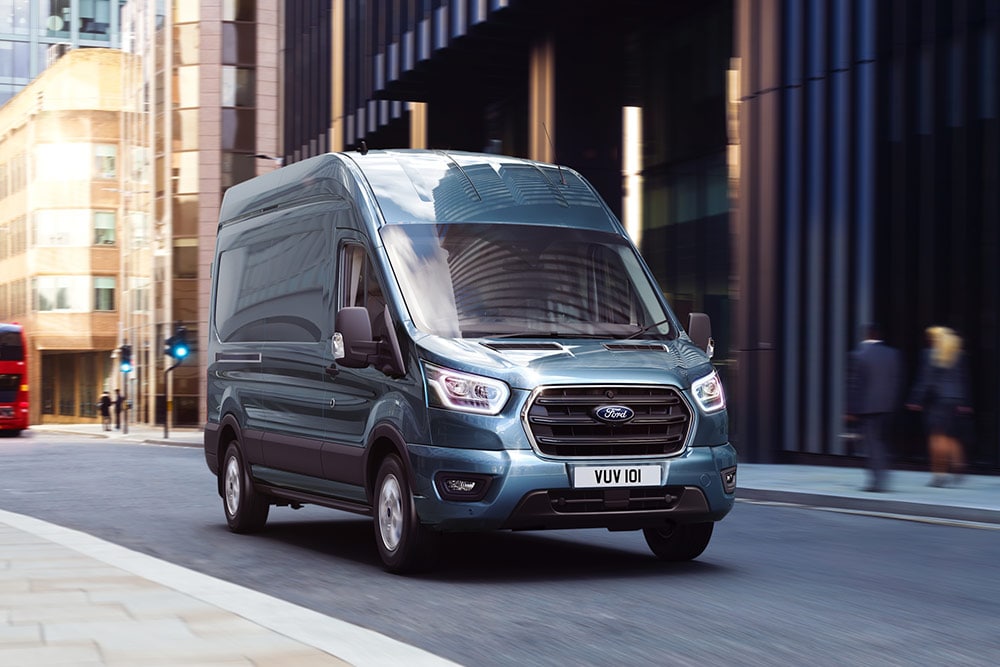 Een Ford Transit-bestelwagen die in de stad rijdt.