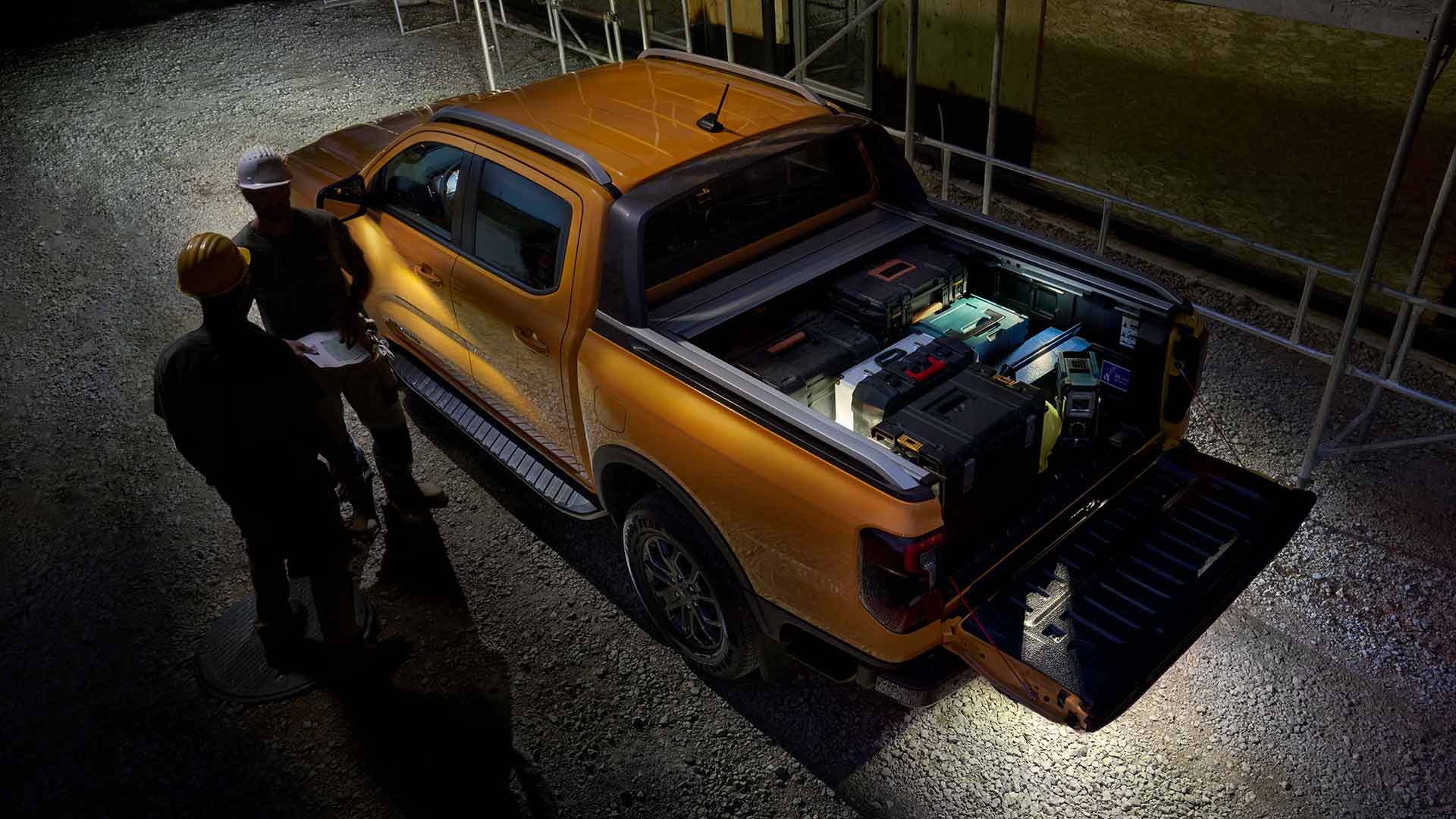 Een bovenaanzicht van de gele Ford Ranger Wildtrak bij nacht met zoneverlichting.