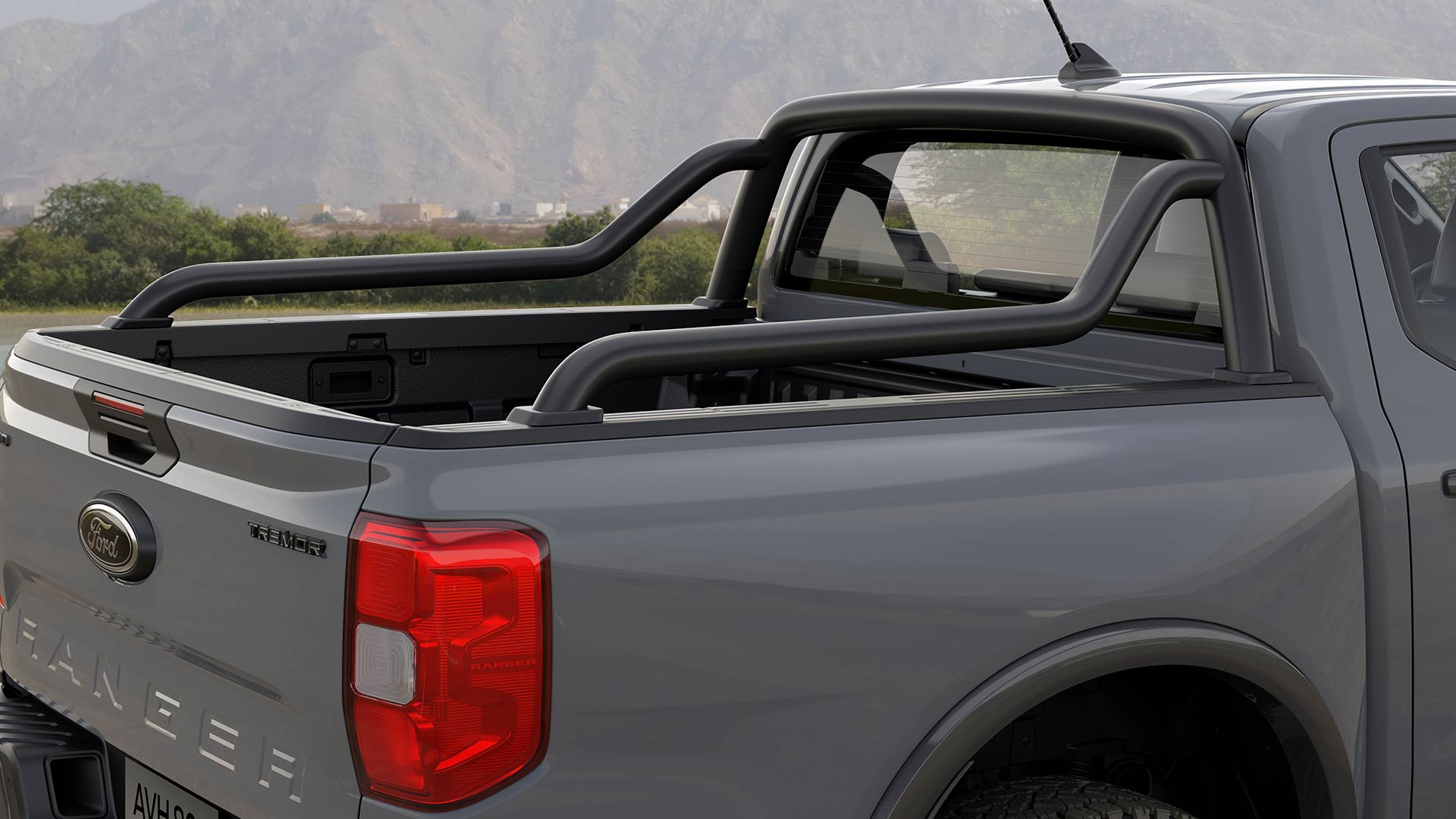 De achterkant van een grijze Ford Ranger met dubbele cabine en sportieve stangen.