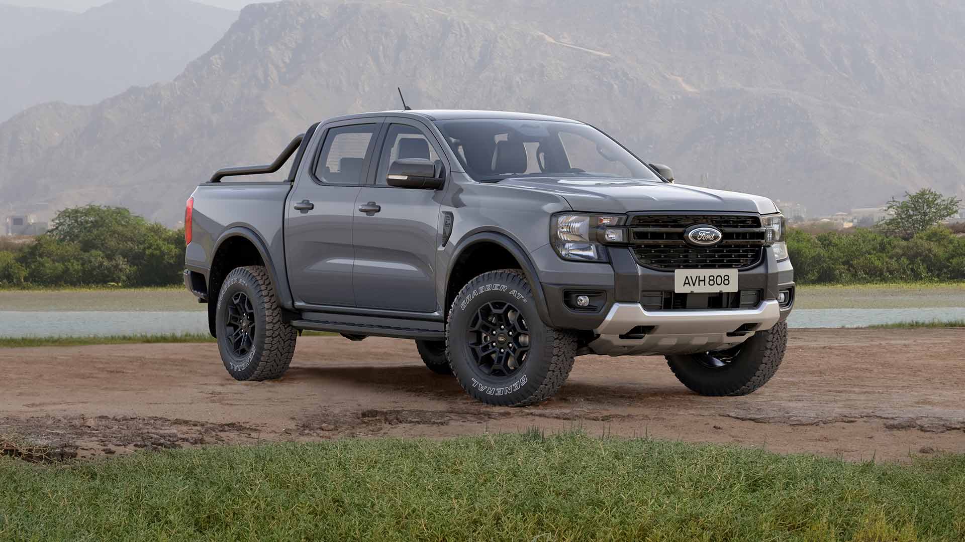 Een grijze Ford Ranger met dubbele cabine rijdt over een onverharde weg.