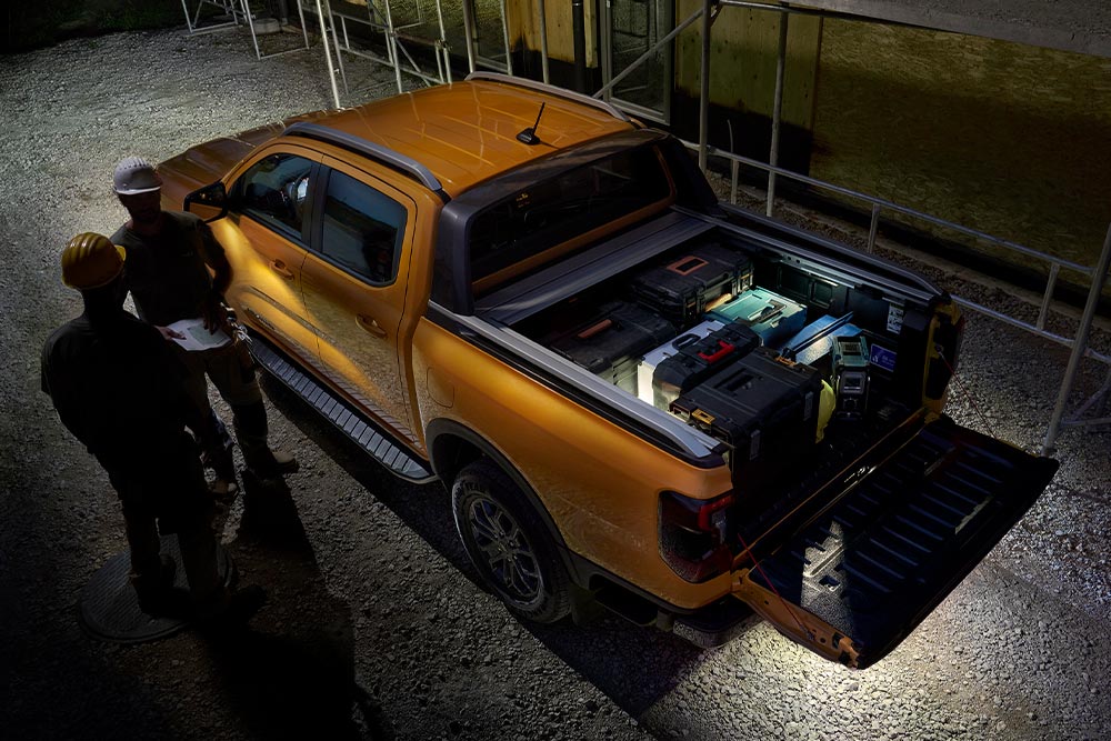 Bovenaanzicht van de gele Ford Ranger Wildtrak 's nachts met buitenverlichting.
