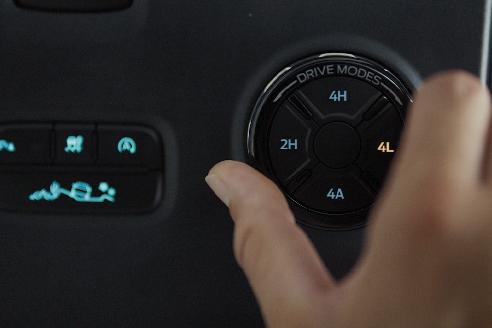 Een hand selecteert een rijmodus met het keuzewiel van de Ford Ranger.