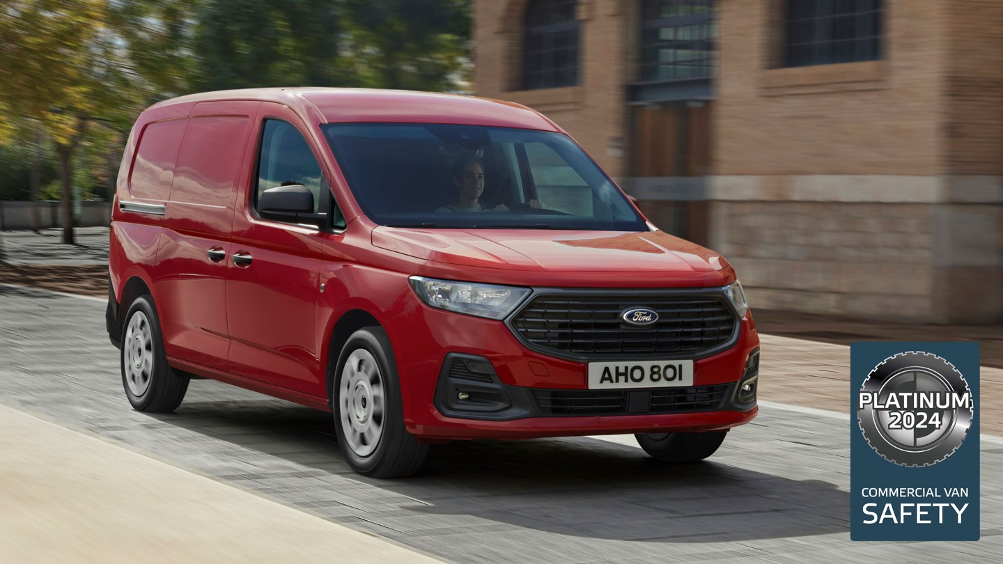 Nieuwe Ford Transit Connect Trend in Maple Red met grille en automatische koplampen rijdt door een straat. 