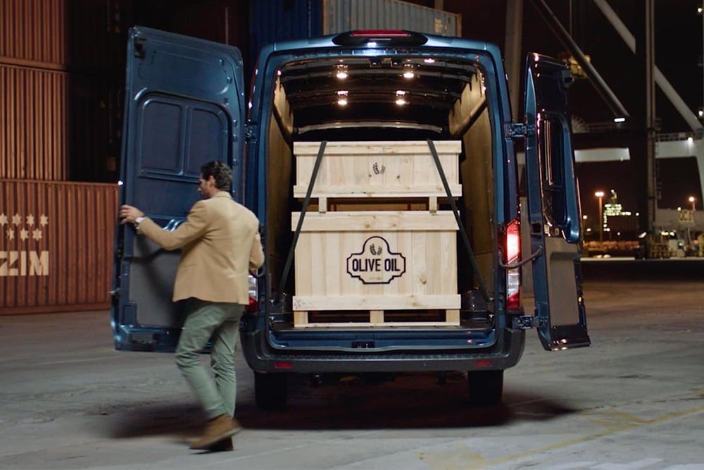 Ford Transit-bestelwagen met open achterdeuren en lading in de laadruimte.