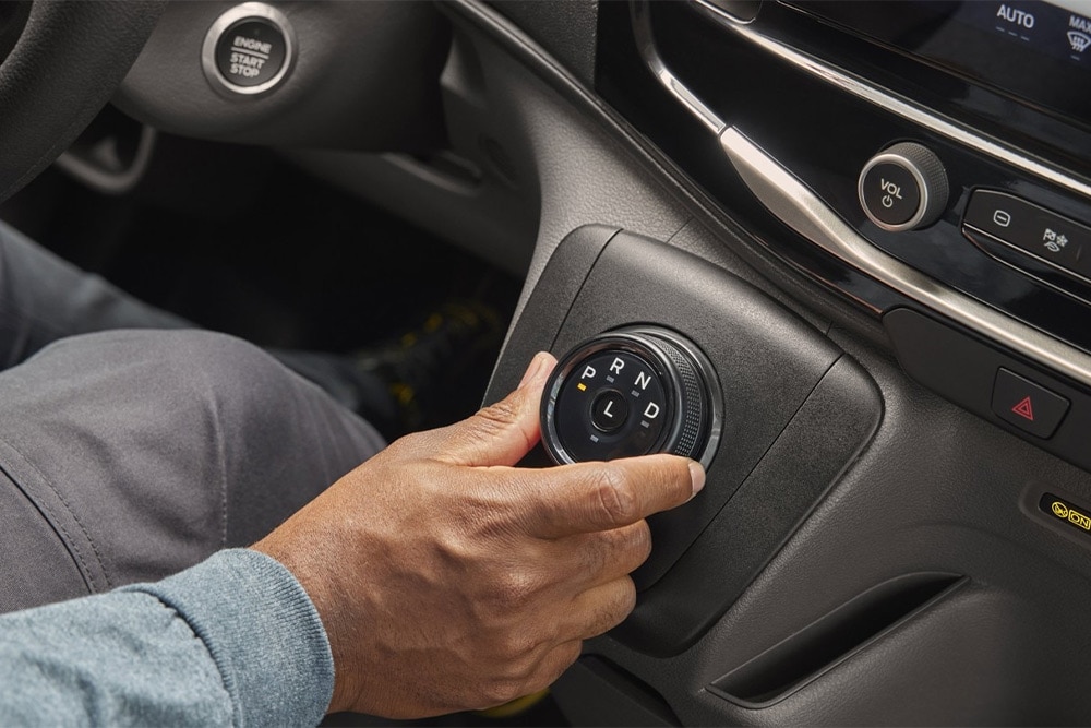 Hand die de draaischakelaar in de middenconsole van de Ford Transit-bestelwagen bedient. 