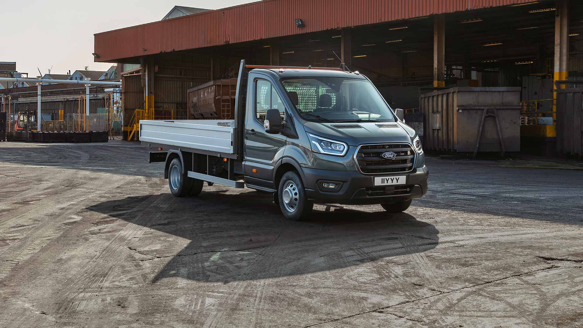 Een Ford Transit-chassis met cabine geparkeerd op een industrieterrein. 