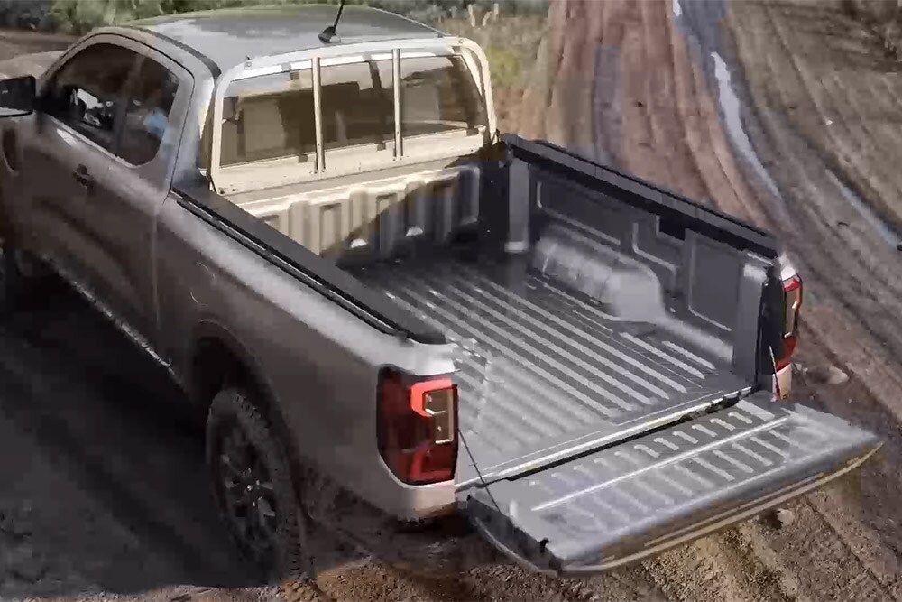 Een zilverkleurige Ford Ranger XLT Super Cab die op een modderige ondergrond geparkeerd staat, met de achterklep open, van bovenaf gezien.